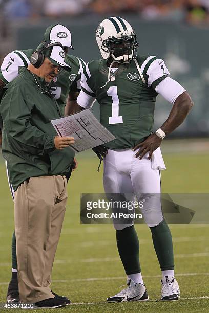 Quarterback Michael Vick of the New York Jets speaks with Offensive Coordinator Marty Mornhinweg in the game against the Indianapolis Colts during a...