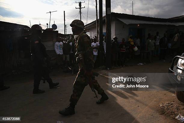 Liberian security forces, part of the country's Ebola Task Force, enforce a quarantine on the West Point slum on August 20, 2014 in Monrovia,...