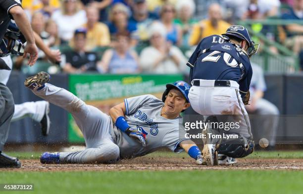 Jonathan Lucroy of the Milwaukee Brewers can not make the catch to put the tag on Munenori Kawasaki of the Toronto Blue Jays at Miller Park on August...