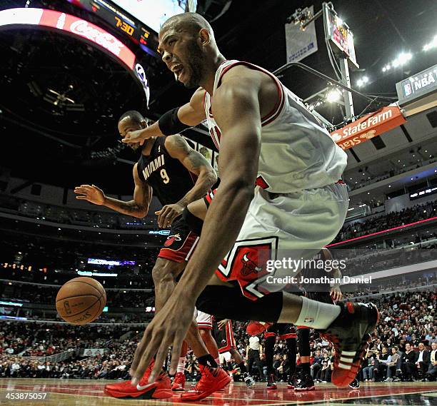 Taj Gibson of the Chicago Bulls falls out of bounds trying for a loose ball under poressure from Rashard Lewis of the Miami Heat at the United Center...