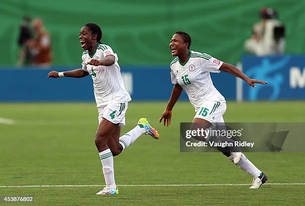 Asisat Oshoala and Ugo Njoku of Nigeria celebrate victory following the final whistle of the FIFA U-20 Women's World Cup Canada 2014 Semi Final match...