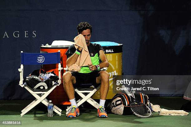 Mikhail Kukuskin of Kazakhstan rests between side change during his matich with John Isner during the Winston-Salem Open at Wake Forest University on...