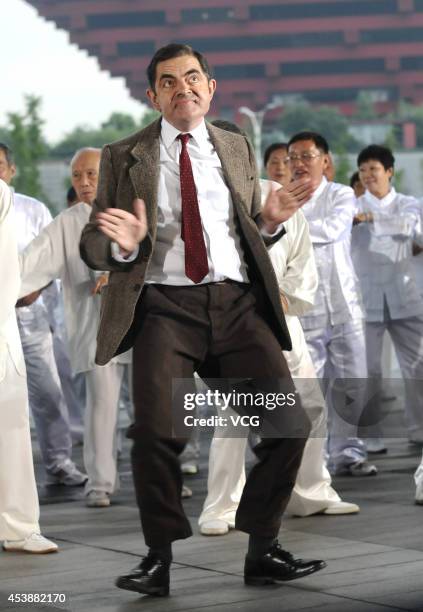 Actor Rowan Atkinson as Mr. Bean performs square dance during a programme recording on August 21, 2014 in Shanghai, China.