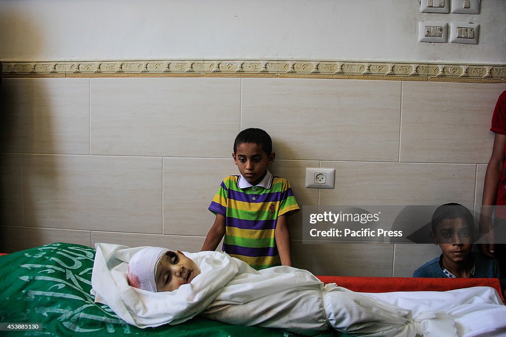 Palestinians mourn during the burial of the infant son of...