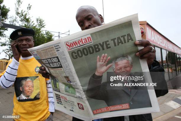 Man reads, in Soweto on 6, 2013 the Sowetan newspaper showing a front page dedicated to South African former President Nelson Mandela as they pay...