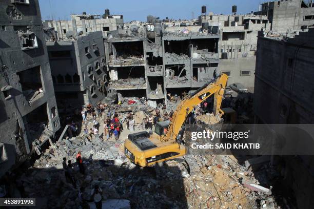 Palestinian emergency personnel dig through the rubble of a building destroyed following an Israeli military strike in Rafah in the south of the Gaza...