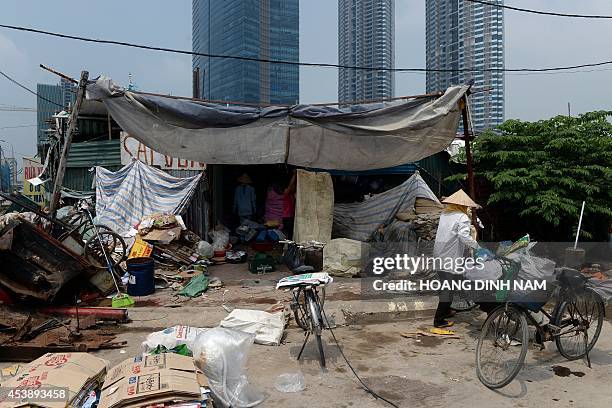 Collectors of recyclable items sell what they collected at a trader's buying point set up near the Keanang buildings , Vietnam's tallest building, at...