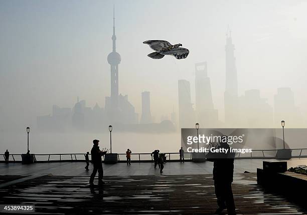 Man flies kite at The Bund on December 5, 2013 in Shanghai, China. Heavy smog continued to hit northern and eastern parts of China on Thursday,...