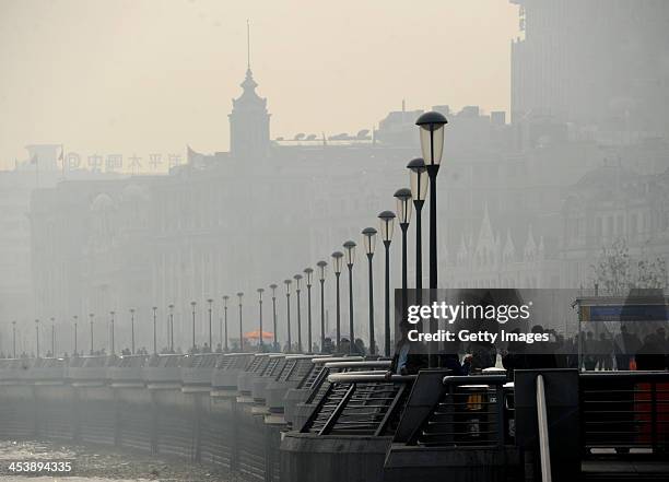 People wander at The Bund on December 5, 2013 in Shanghai, China. Heavy smog continued to hit northern and eastern parts of China on Thursday,...