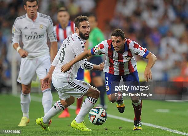 Koke of Club Atletico de Madrid gets the better of Daniel Carvajal of Real Madrid during the Supercopa first leg match between Real Madrid and Club...