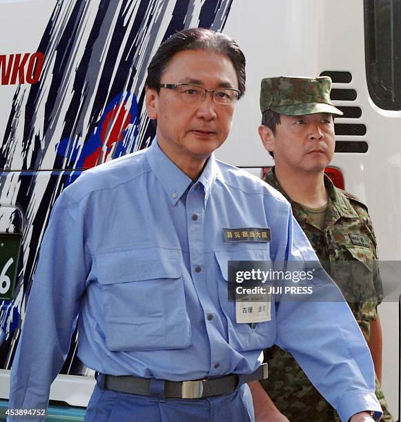 Japanese minister in charge of disaster prevention Keiji Furuya inspects a landslide site in Hiroshima, western Japan, on August 21 one day after a...