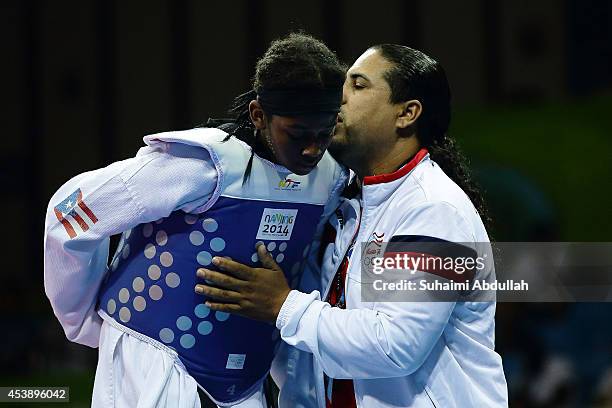 Crystal Weekes Gonzalez of Perto Rico is comforted by her coach after losing to Li Chen of China in the taekwondo women 63kg quarter finals on day...