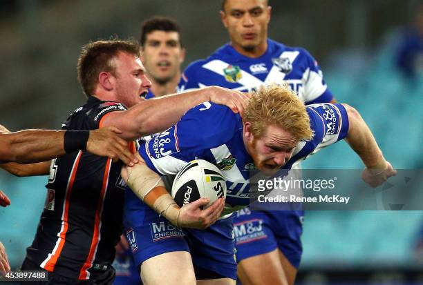James Graham of the Bulldogs is tackled by Matt Lodge of the Tigers during the round 24 NRL match between the Canterbury Bulldogs and the Wests...