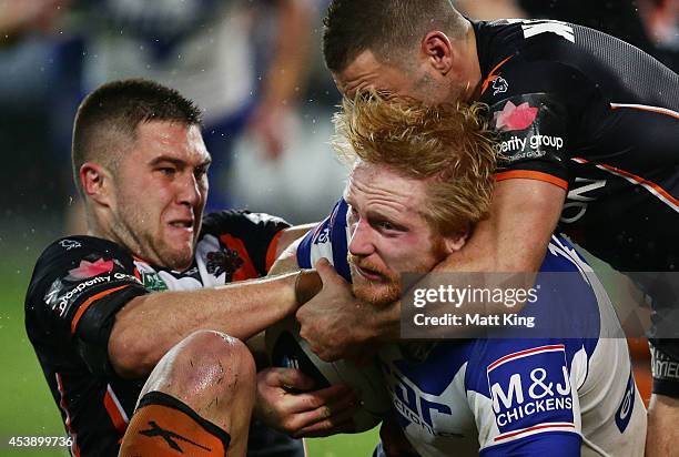 James Graham of the Bulldogs is tackled during the round 24 NRL match between the Canterbury Bulldogs and the Wests Tigers at ANZ Stadium on August...