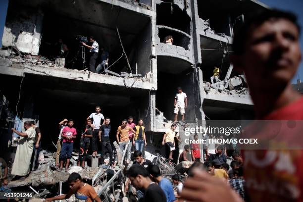 Palestinian gather around the rubble of a building destroyed following an Israeli military strike in Rafah in the south of the Gaza Strip on August...