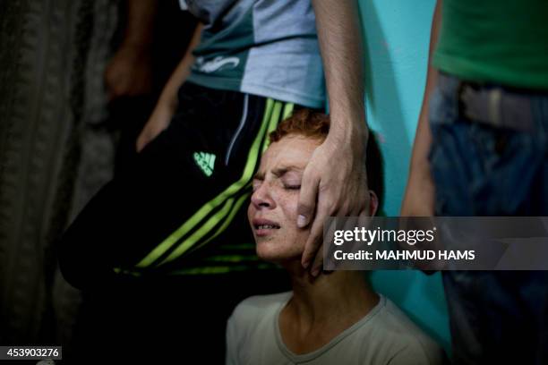 Relatives of senior Hamas commander Raed al-Atar, one of three senior Hamas commanders killed in an Israeli military strike, mourns during his...