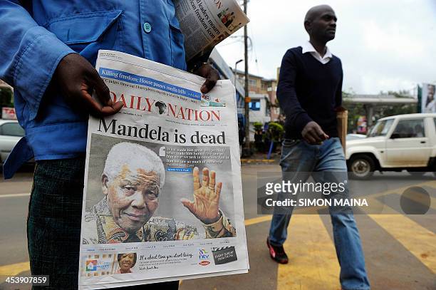 Newspaper vendor sells local issues with headline on the death of former South African president Nelson Mandela on December 6, 2013 in Nairobi....