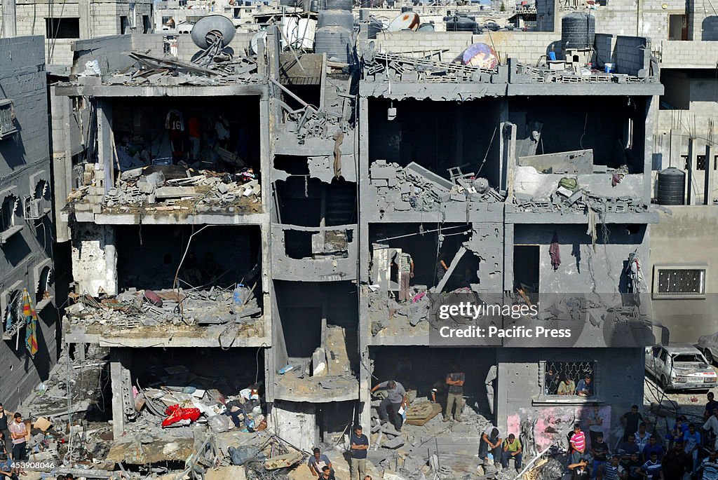 Palestinians gather inside a destroyed building, following,...