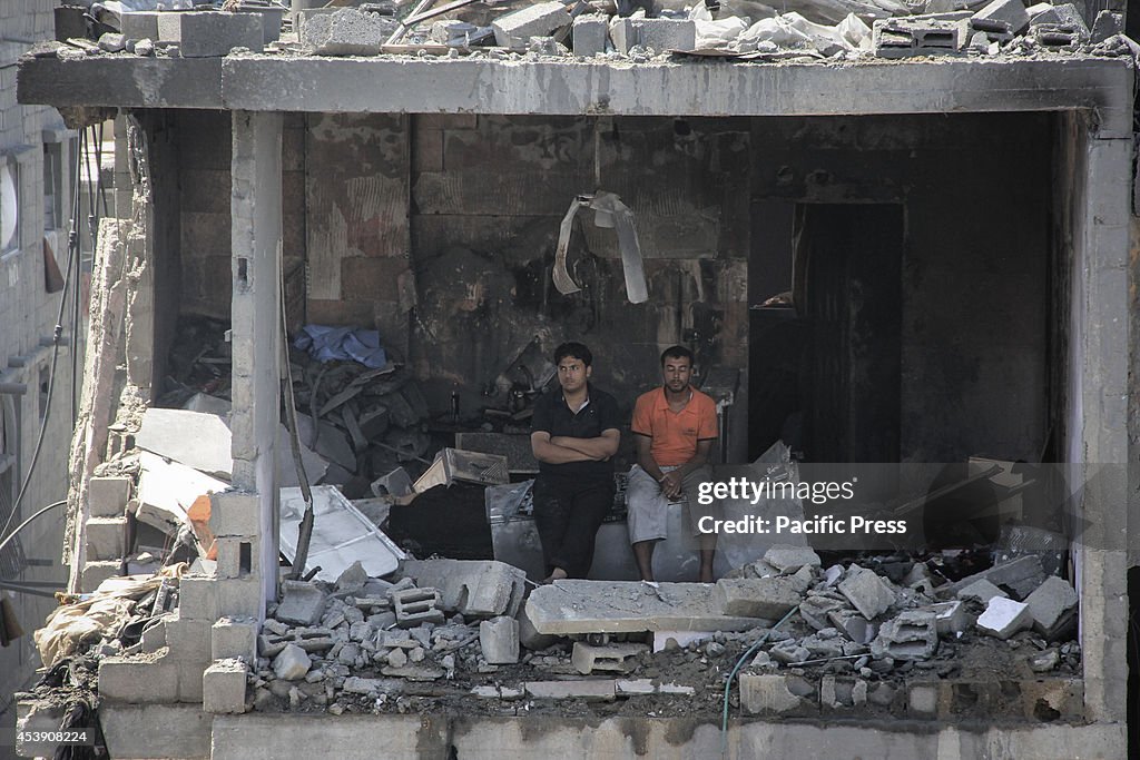 Local residents gather in one of the destroyed buildings...