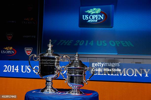 The Men's Singles and Women's Singles U.S. Open trophies are seen during the draw ceremony prior to the start of the 2014 U.S. Open at the USTA...