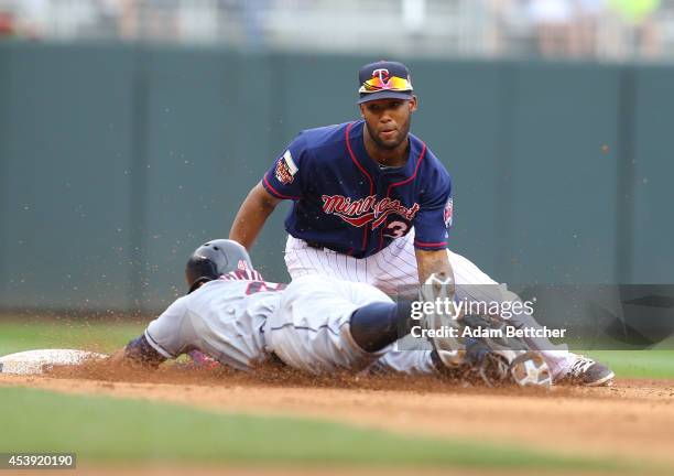 Danny Santana of the Minnesota Twins attempts the tag of Carlos Santana of the Cleveland Indians at Target Field on August 21, 2014 in Minneapolis,...