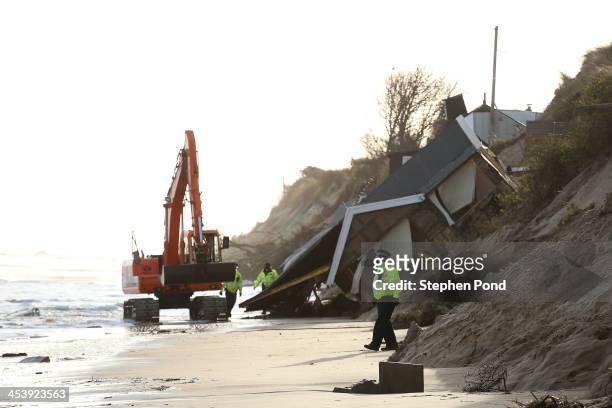 Police Officers secure the beach where properties have fallen into the sea due to the cliff collapsing on December 6, 2013 in Hemsby, England....