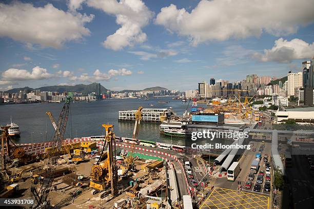 Cranes operate at a land reclamation construction site in the Wan Chai district of Hong Kong, China, on Thursday, Aug. 21, 2014. Slowing economic...