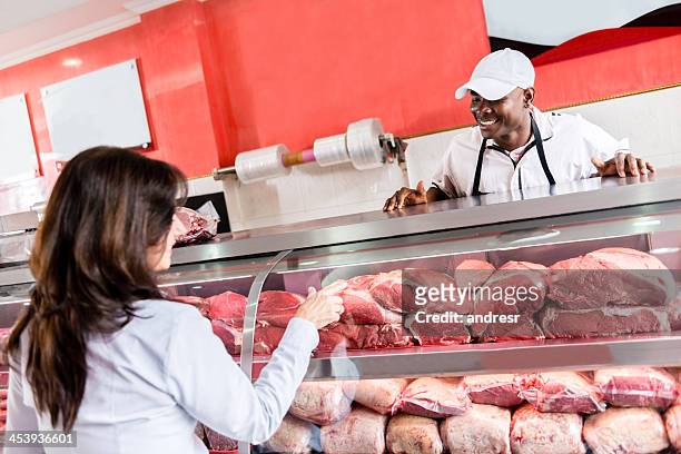 mujer comprando el despiece de la carne - butchers shop fotografías e imágenes de stock