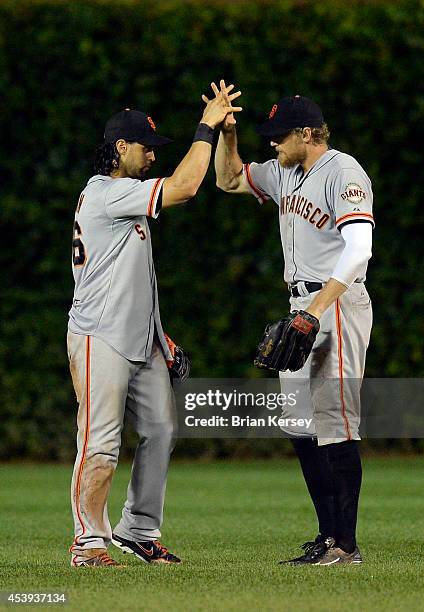 Angel Pagan and Hunter Pence of the San Francisco Giants celebrate their win over the Chicago Cubs at Wrigley Field on August 21, 2014 in Chicago,...