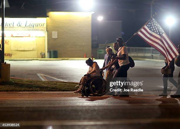 Demonstrators protesting the shooting death of teenager Michael Brown by police march through the streets on August 21, 2014 in Ferguson, Missouri....