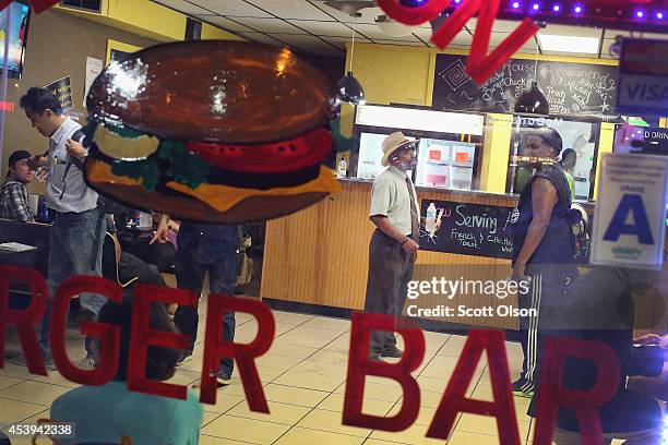 Customers hang out at the Ferguson Burger Bar as the town struggles to return to normal following several days of riots, looting and violent protests...