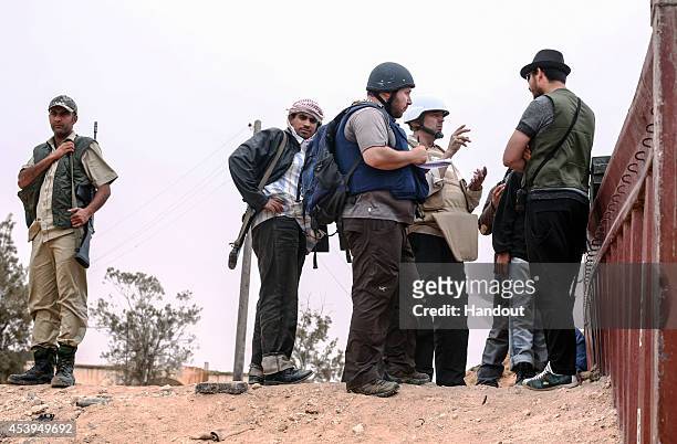 In this handout image made available by the photographer American journalist Steven Sotloff talks to Libyan rebels on the Al Dafniya front line, 25...