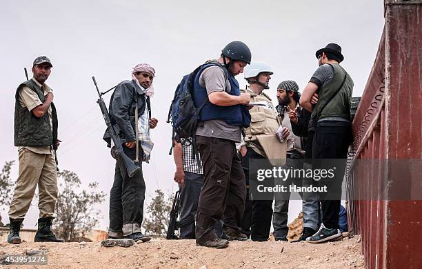 In this handout image made available by the photographer American journalist Steven Sotloff talks to Libyan rebels on the Al Dafniya front line, 25...