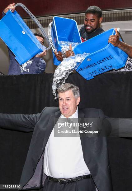 Tim Leiweke, spreads his arms just before MLSE stars Nazem Kadri, Amir Johnson, and Jermain Defoe, dump ice water on him as part of the Ice Bucket...