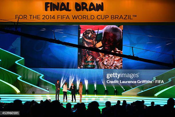 Tribute to Nelson Mandela is displayed on a screen as FIFA President Joseph S. Blatter, Brazil President Dilma Rousseff and hosts Fernanda Lima and...