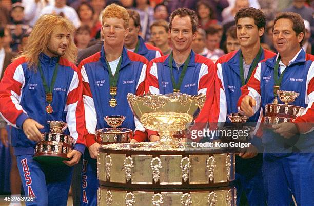 Andre Agassi, Jim Courier, John McEnroe, Pete Sampras, and captain Tom Gorman victorious with trophy after defeating Switzerland to win tournament at...