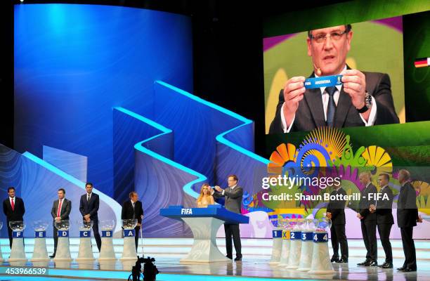 Secretary General Jerome Valcke holds up the name of Argentina during the Final Draw for the 2014 FIFA World Cup Brazil at Costa do Sauipe Resort on...