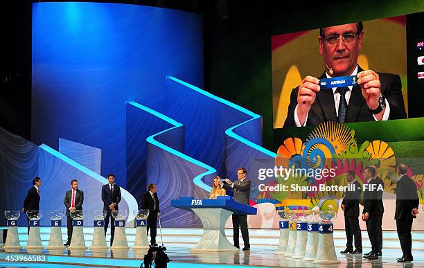 Secretary General Jerome Valcke holds up the name of Australia during the Final Draw for the 2014 FIFA World Cup Brazil at Costa do Sauipe Resort on...