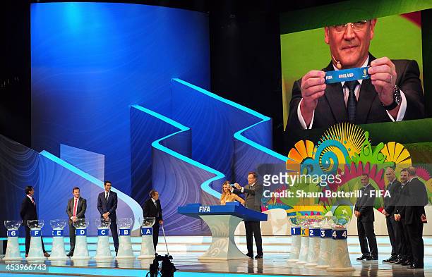 Secretary General Jerome Valcke holds up the name of England during the Final Draw for the 2014 FIFA World Cup Brazil at Costa do Sauipe Resort on...
