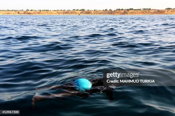 The body of an illegal immigrant floats on the water after a boat carrying 200 illegal migrants from sub-Saharan Africa sank off the shores of...