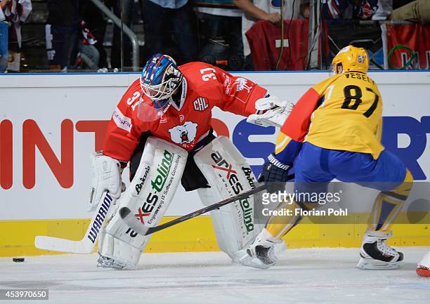Ondrej Vesely of PSG Zlin passes the puck against Petri Vehanen of Eisbaeren Berlin during the Champions Hockey League group stage game between...