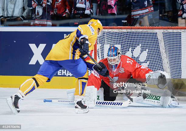 Ondrej Vesely of PSG Zlin attempts to score against Petri Vehanen of Eisbären Berlin during the Champions Hockey League group stage game between...
