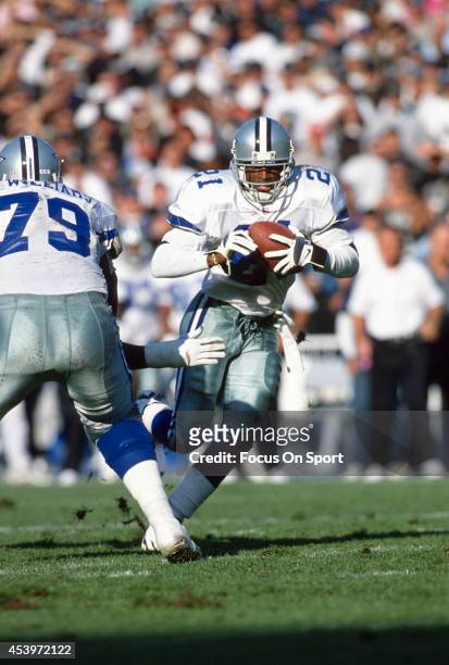 Deion Sanders of the Dallas Cowboys carries the ball against the Oakland Raiders during an NFL football game November 19, 1995 at the Oakland-Alameda...
