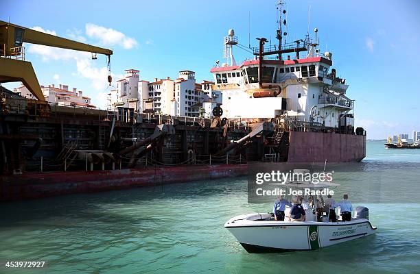 Florida Governor Rick Scott and other officials ride in a boat as they pass the Terrapin Island a dredging ship that is part of the start-up of...