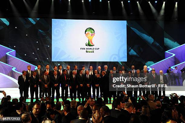 The coaches of the national football teams of the 32 nations that have qualified for the 2014 World Cup Finals pose on stage with FIFA President...