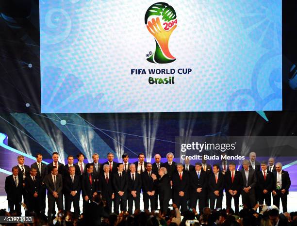 The coaches of the national football teams of the 32 nations that have qualified for the 2014 World Cup Finals pose on stage with FIFA President...