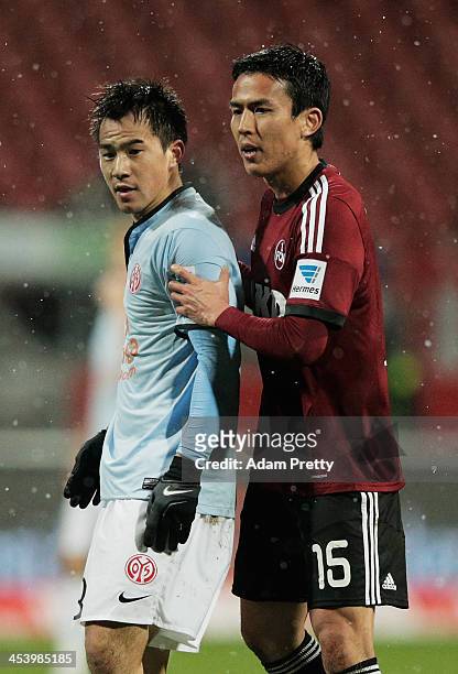 Makoto Hasebe of Nuernberg holds back Shinji Okazaki of Mainz after Okazaki had strong words with the referee during the Bundesliga match between FC...