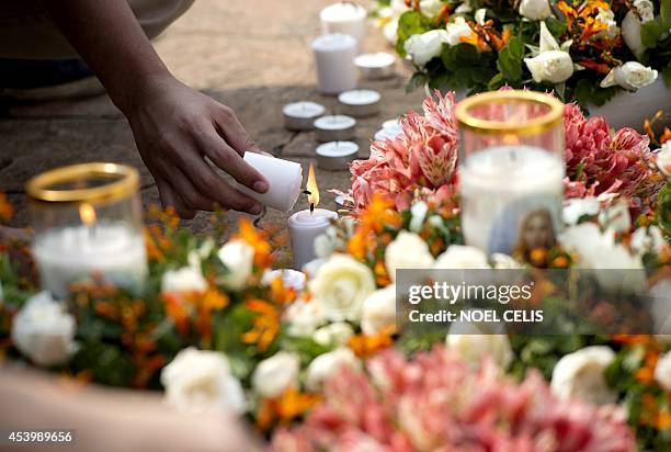 Man lights a candle as he attends a day of special prayers at the Quirino Grandstand in Manila on August 23 in memory of the victims of a...