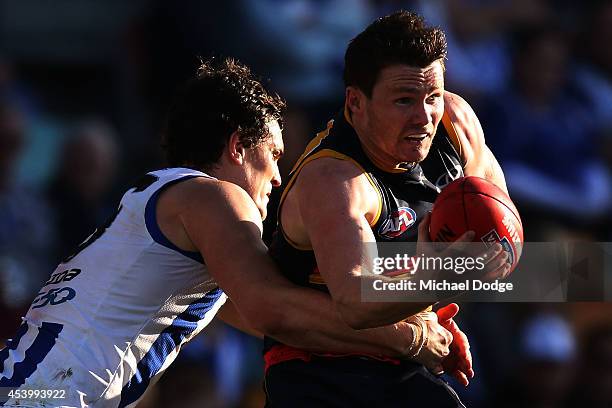 Patrick Dangerfield of the Crows is tackled by Scott Thompson of the Kangaroos during the round 22 AFL match between the North Melbourne Kangaroos...