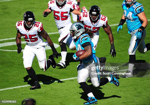 DeAngelo Williams of the Carolina Panthers carries the ball against Akeem Dent and William Moore of the Atlanta Falcons at Bank of America Stadium on...